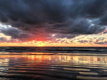 Scenic view of sea against cloudy sky during sunset