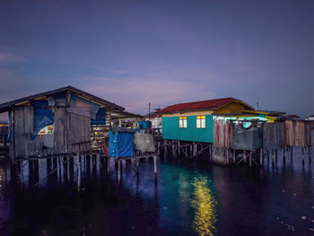 Wooden house and buildings against sky at dusk