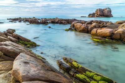 Rock formation in sea against sky