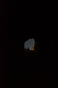 Low angle view of silhouette rock formation against sky