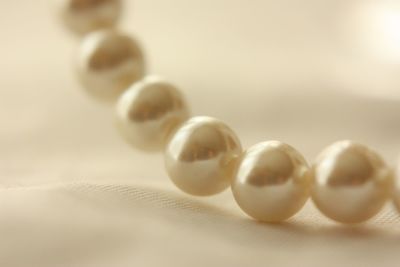 Close-up of pearl necklace on fabric