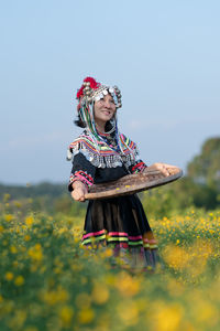 Low angle view of woman climbing on field against sky