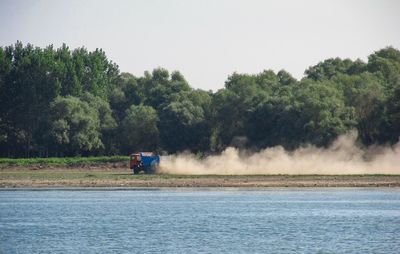 Scenic view of truck leaving dust behind against clear sky