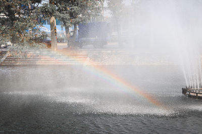 Scenic view of rainbow over sea in city