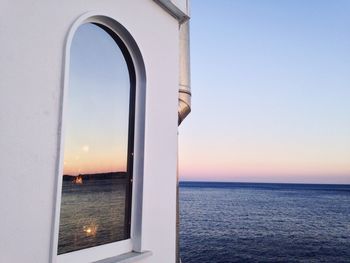 Close-up of sea against clear sky during sunset