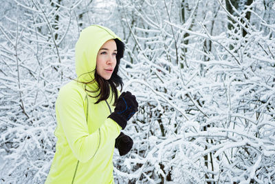 Cold weather running. happy woman running in winter snowy park, forest. running athlete woman