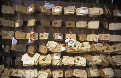 Religious notes hanging against wooden wall