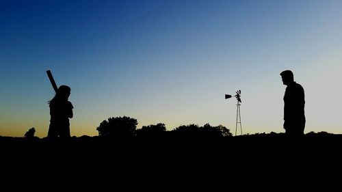 Silhouette people standing against clear sky during sunset