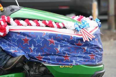 Low section of men riding tractor at street on fourth of july independence day parade