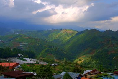 Scenic view of village and houses against sky