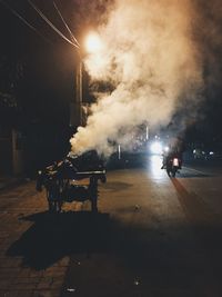 People on illuminated road at night