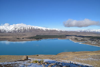 Scenic view of snowcapped mountains against blue sky