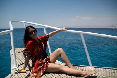 Young woman sailing in sea against sky