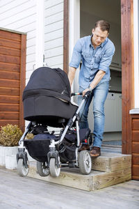 Man with baby carriage leaving house