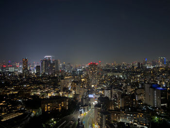 Illuminated cityscape against clear sky at night