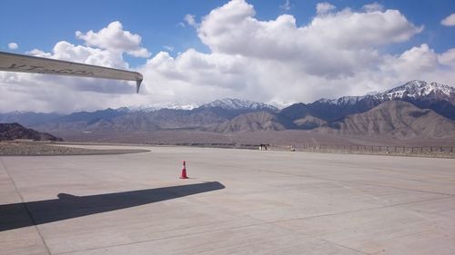 Airplane flying over mountains against sky