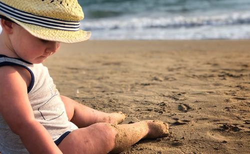 Side view of boy wearing hat on beach