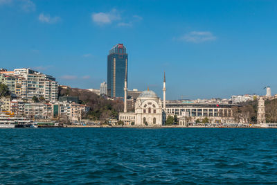 View of buildings at waterfront against blue sky