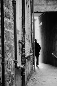 Rear view of woman walking in tunnel