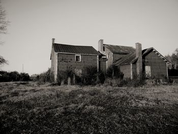 Abandoned house on field against clear sky