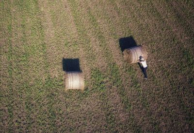 High angle view of man and hay bale on field 