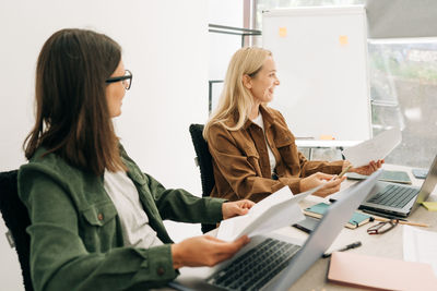 Portrait of woman using laptop at office