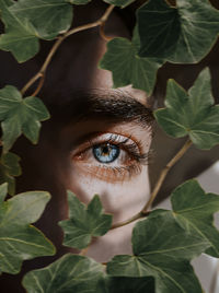 Close-up portrait of young woman with leaves