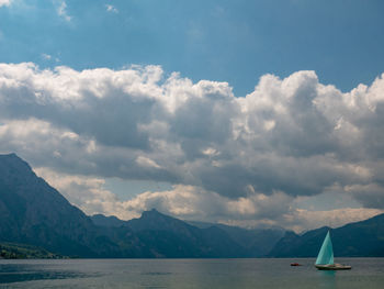 Scenic view of sea by mountains against sky