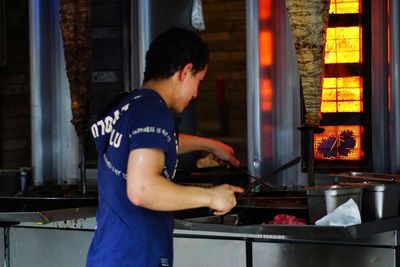 Side view of man preparing food