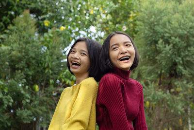 Girls standing against trees