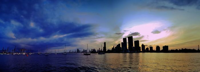 Panoramic view of sea and buildings against sky during sunset