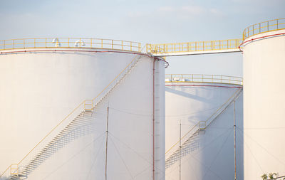 Low angle view of fuel tanks against sky