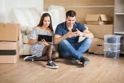 Young woman using mobile phone while sitting at home