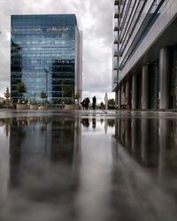 Reflection of buildings in city against sky