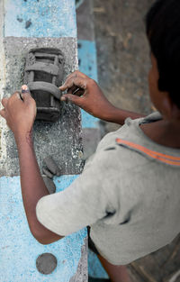 Rural child is making and playing soil clay toy passionately .