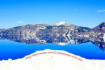 Scenic view of snowcapped mountains against blue sky