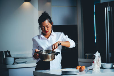 Mid adult woman standing in kitchen at home