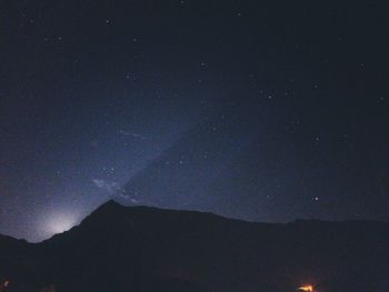 Low angle view of silhouette mountain against sky at night