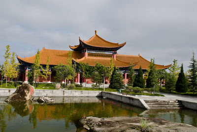 Building by lake against sky