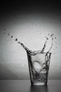 Close-up of water splashing in glass against white background