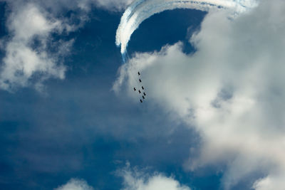 Low angle view of birds flying against sky