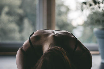 Close-up of woman doing yoga at home