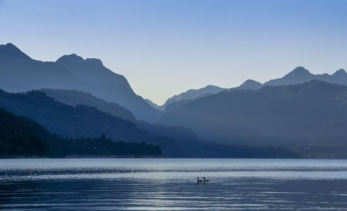 Scenic view of lake and mountains against clear sky