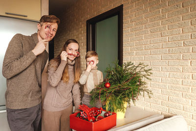 Family decorating the christmas tree against wall