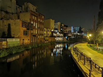River amidst illuminated buildings in city at night