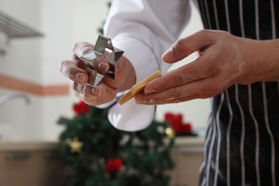 Midsection of chef cutting dough with pastry cutter