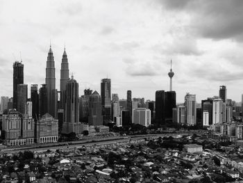 View of skyscrapers in city against cloudy sky