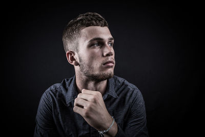 Portrait of man against black background