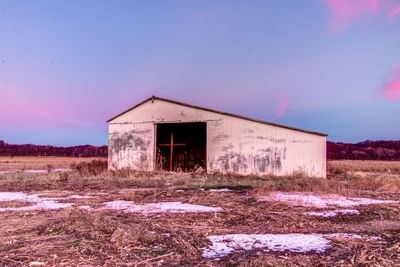 Abandoned built structure on field against sky