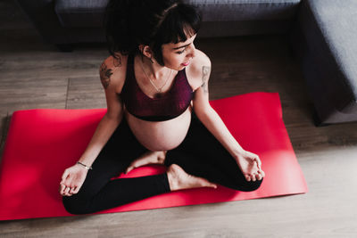 Pregnant woman exercising while sitting at home